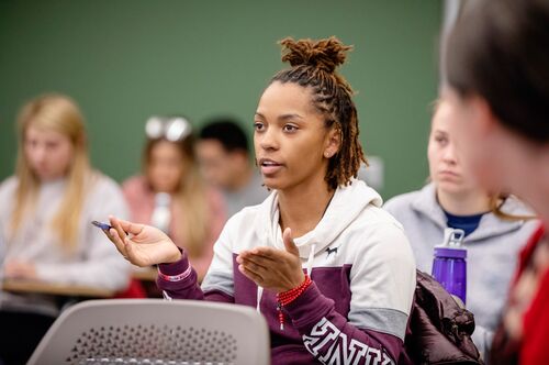 A student gestures as she makes a point in class