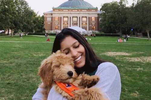 A student cuddles with her dog on the Main Quad