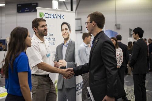 People shake hands at a career fair