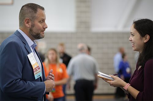 A student talks to a recruiter at the ACES + LAS Career Fair