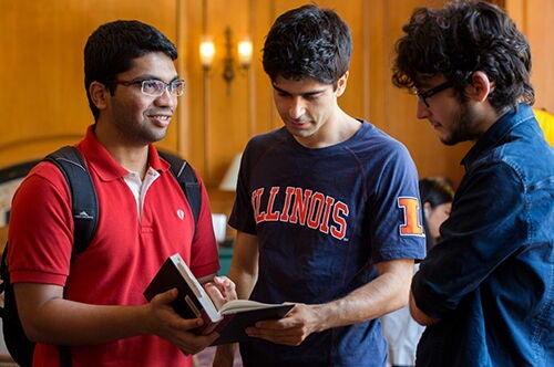 Students point to a book