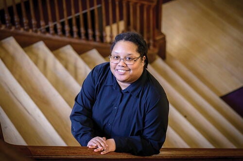 Anthropology professor LaKisha David standing at the stairs in the Main Library