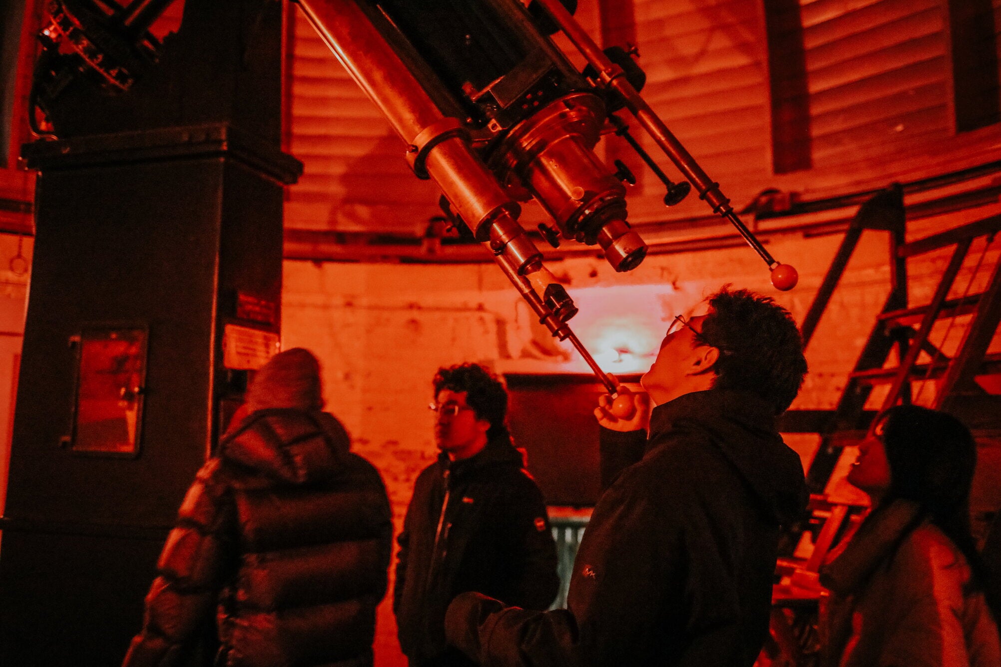student looks through telescope
