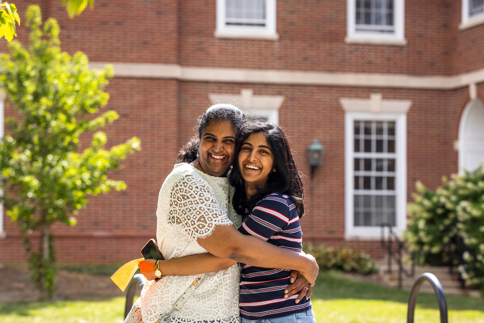 A parent and student hug during move-in