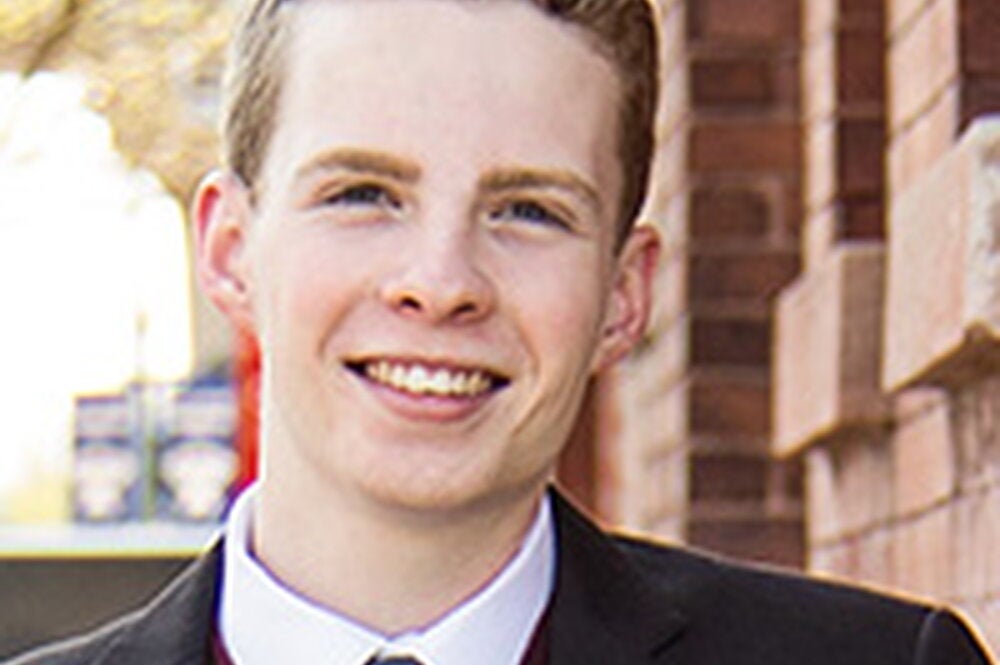LAS student poses for photo in black suit and blue tie