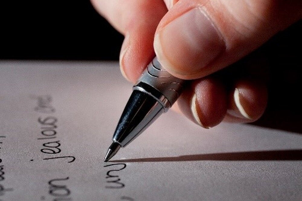 Student holding a pen, writing a thank-you letter