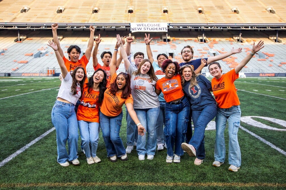 students standing in the middle of Memorial Stadium in Illini gear