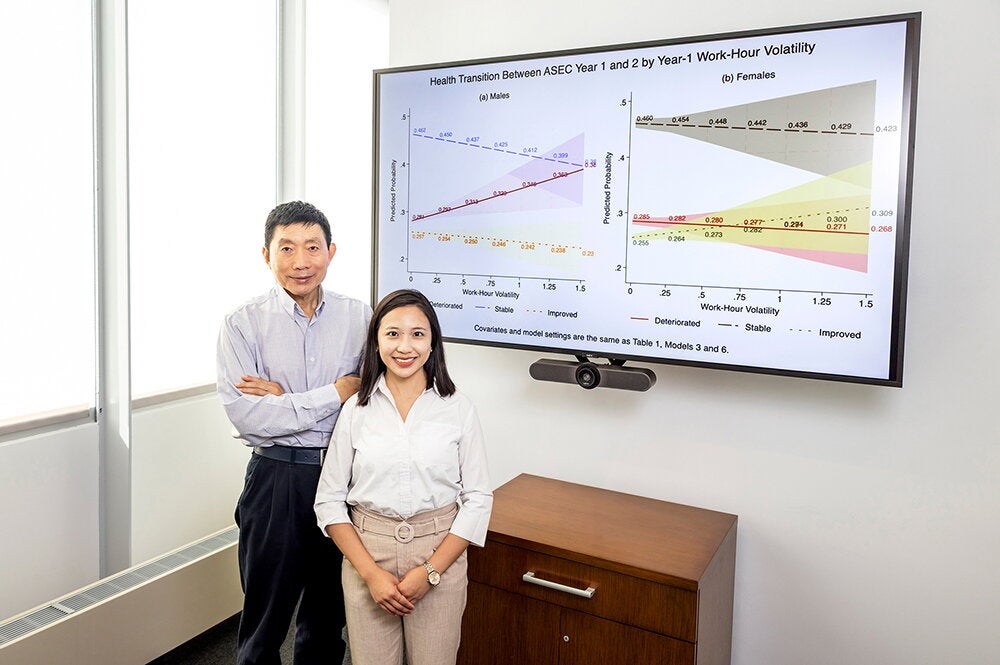 Liao and Lu in front of a slideshow