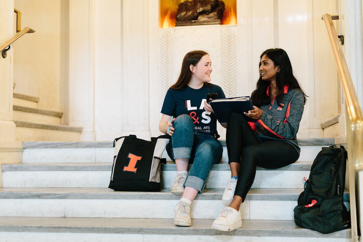 students sit in front of Lincoln statue