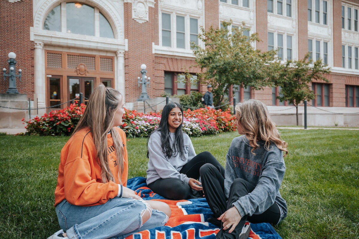 students sitting on blanket in front of lincoln hall