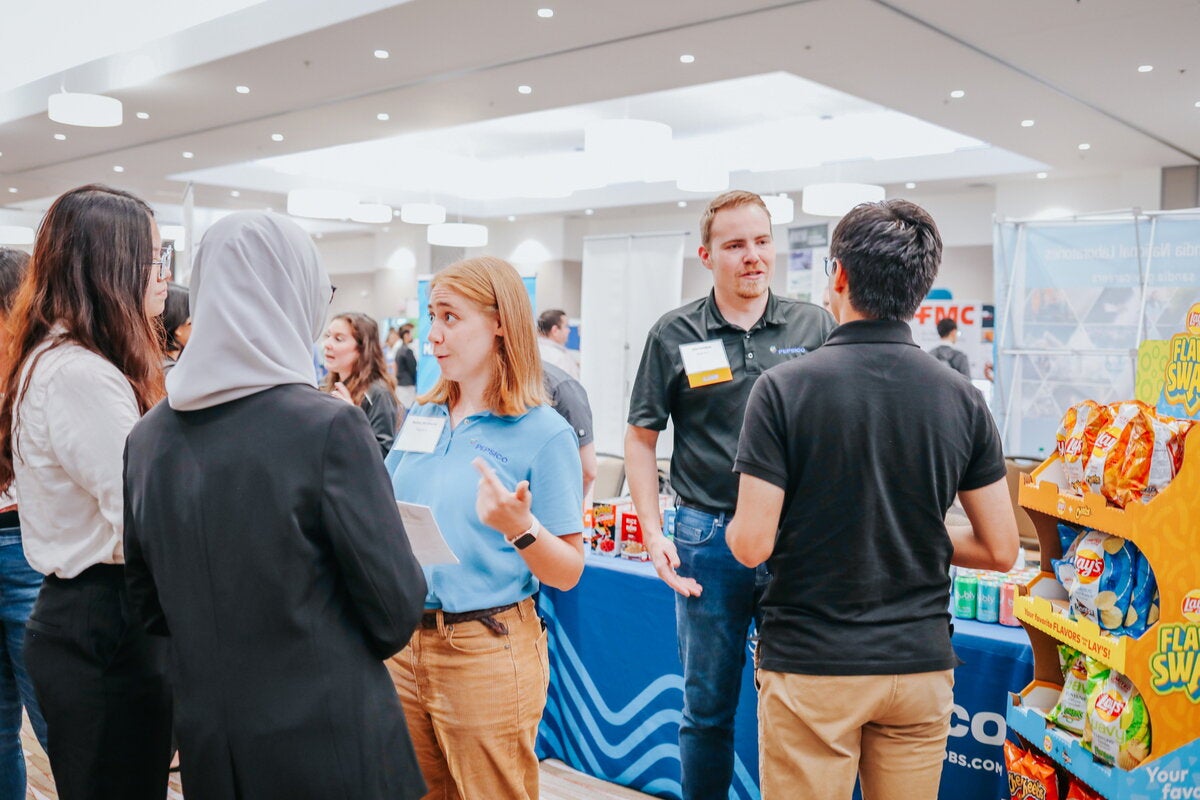 Student speaking to recruiters at a career fair. 
