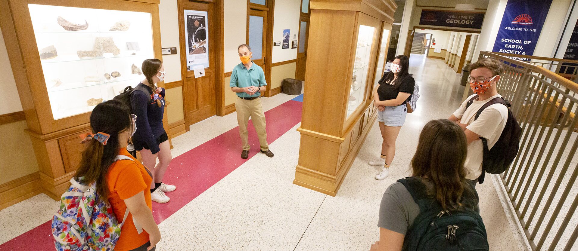 Students listen to a lecture in the Natural History Building while socially distanced and wearing masks