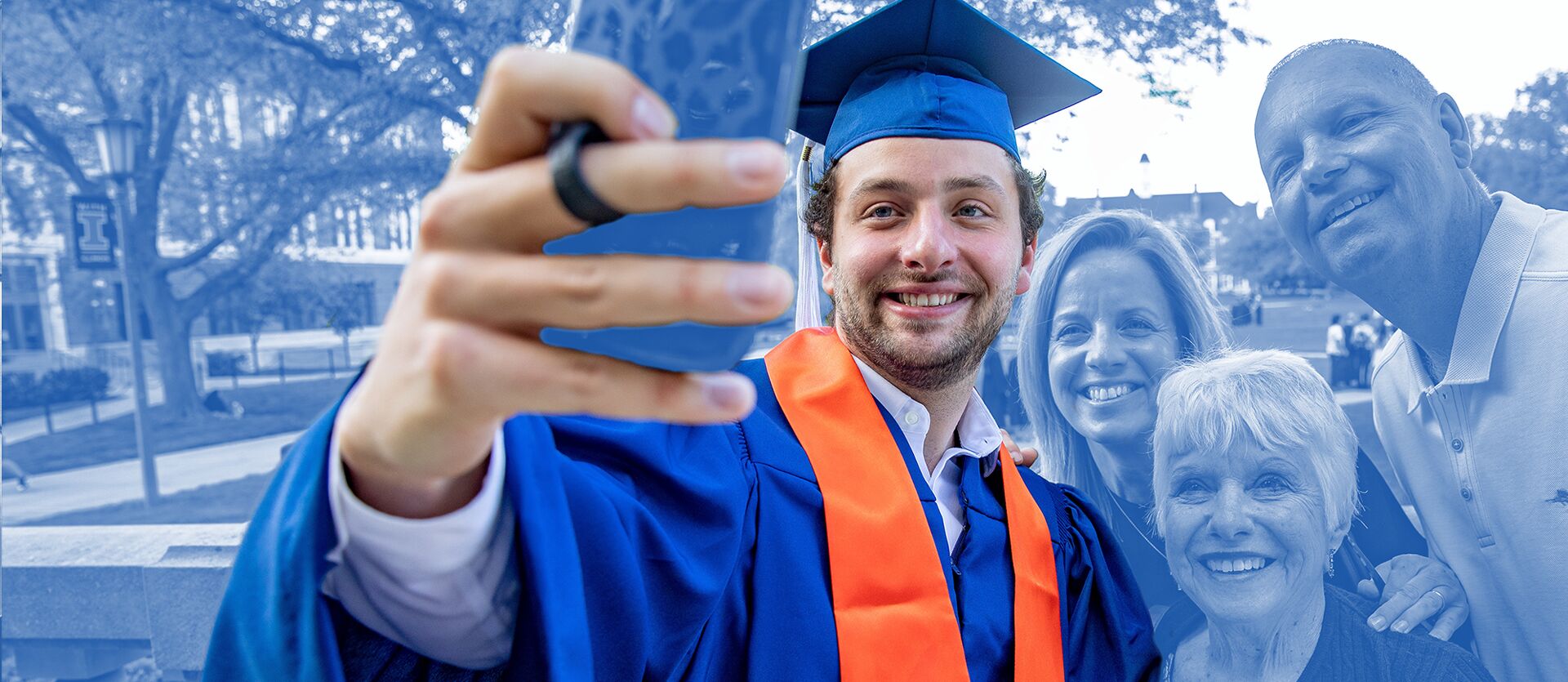 A student snaps a photo of himself in graduation robes