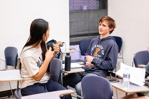 Two students engaging in discussion in class