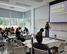 GLP member Keisha speaking in front of a crowd in a classroom 