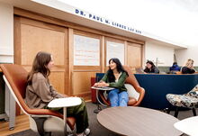 Two students sitting across form each other and talking at the Paul S. Lisnek LAS Hub