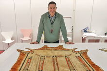 History professor Robert Morrissey at Musee du quai Branly-Jacques Chirac in Paris with a robe featuring one of the best examples of the tribes' hide-painting tradition. (Photo courtesy of Robert Morrissey.)