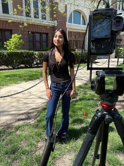 Ariana Dominguez standing in front of a camera on the Quad side of Lincoln Hall.