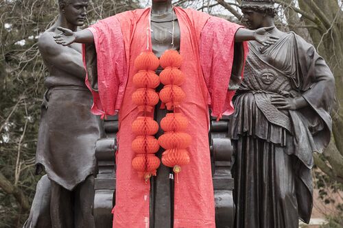 The Alma Mater statue dressed in a red robe with Chinese lanterns draped around her neck