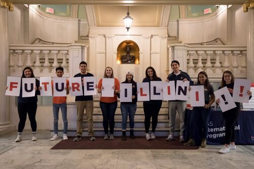 Students hold up cards to say "Future Illini!!"