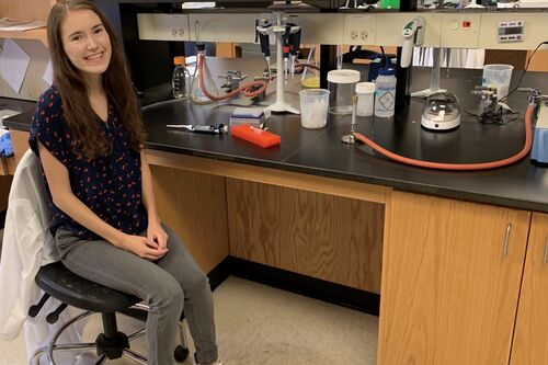 LAS student poses for a photo in her research lab on campus