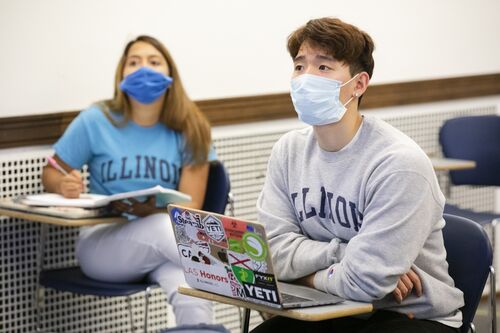 Students participate in a discussion during class. They're masked.