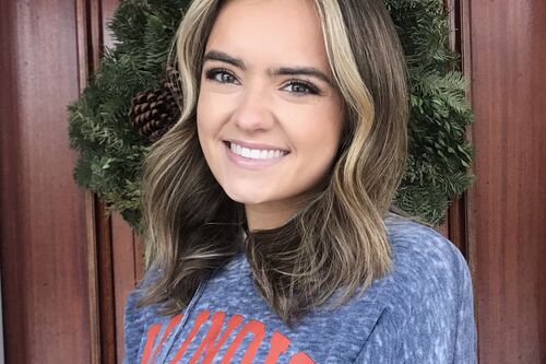 LAS student poses for photo in blue Illinois sweatshirt at her home
