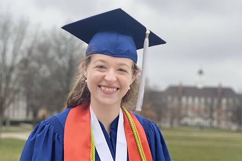 LAS student poses for graduation photo on the Main Quad