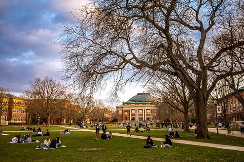 people sitting and standing in groups on the Quad on a partly sunny spring day