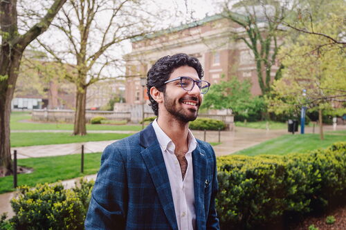 Illinois student in business casual attire standing near Foellinger Auditorium