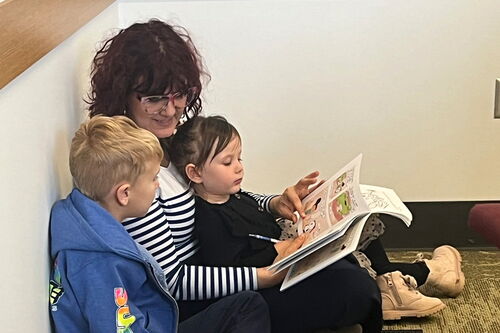 Children and a parent reading a book