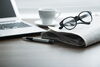 Glasses, newspaper, and a laptop