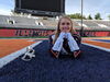 Student poses for photo in Marching Illini uniform on the field at Memorial Stadium