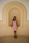 LAS student poses for a photo in a pink dress against a white wall