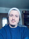 A student sits at a desk with a blue sweater on