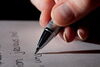 Student holding a pen, writing a thank-you letter