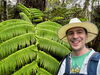Max Christie in front of a green plant. 