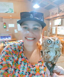 A student holds a small owl