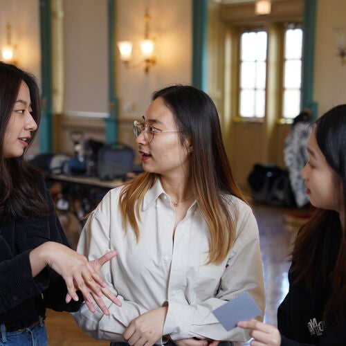 Three students speaking to each other in the Illini Union Ballroom