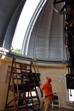 Person opening astronomy dome in campus observatory