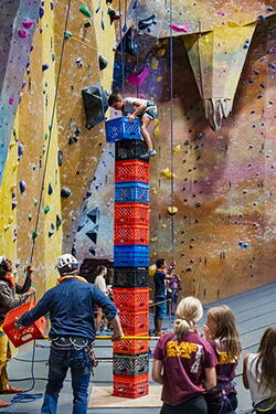 Child climbing stack of crates